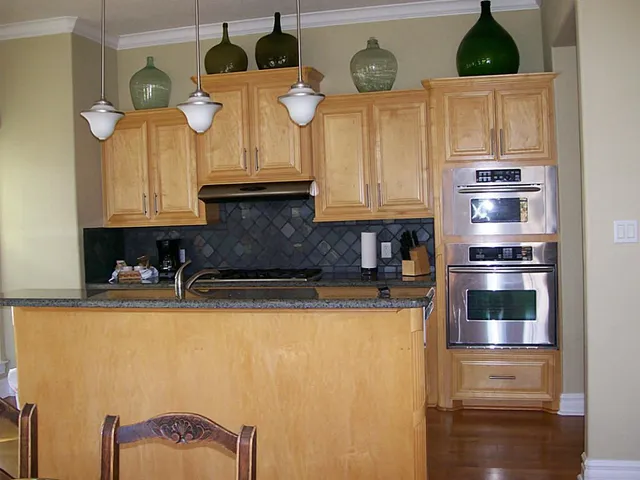 a kitchen with stainless steel appliances granite countertop a refrigerator a stove and a sink