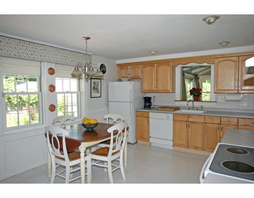 9 Pilgrim Road Hamilton, MA 01982 - Photo 13 of 26 a kitchen with a dining table chairs and white cabinets