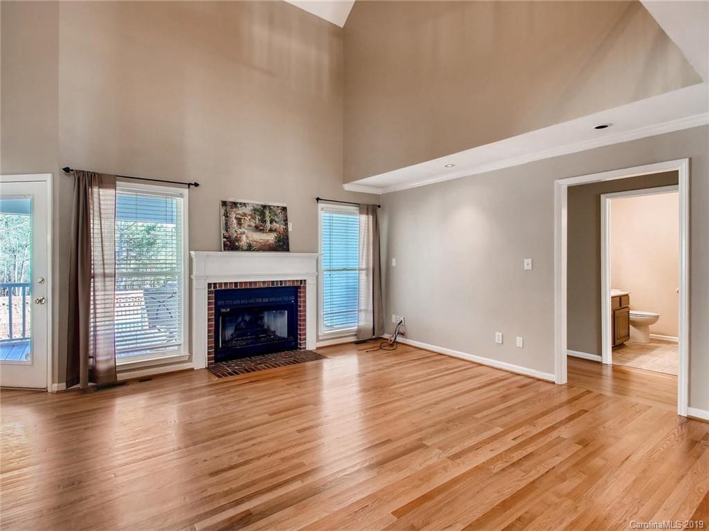 2484 Holbrook Road Fort Mill, SC 29715 - Photo 8 of 36 an empty room with wooden floor fireplace and windows