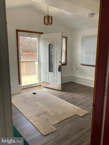 an empty room with wooden floor and mirror