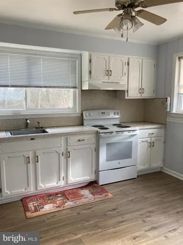 a kitchen with a stove a sink and a window