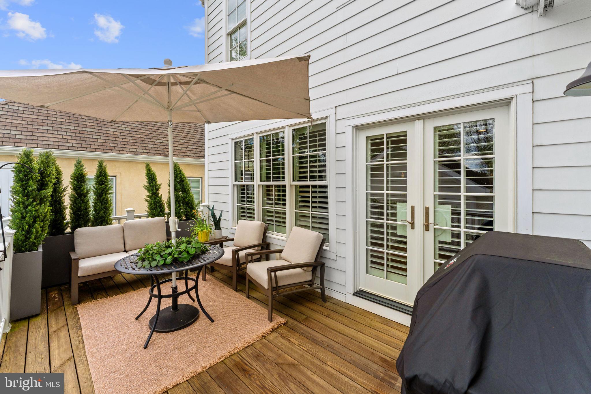 105 Reed Street Middleburg, VA 20117 - Photo 58 of 62 a view of a patio with a dining table and chairs with wooden floor and fence