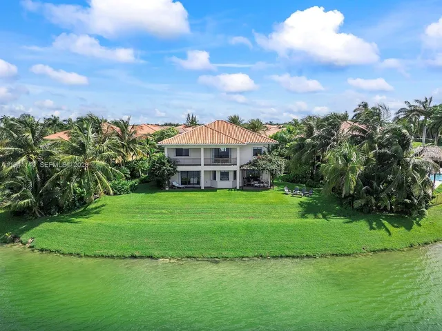 a front view of a house with a garden and trees