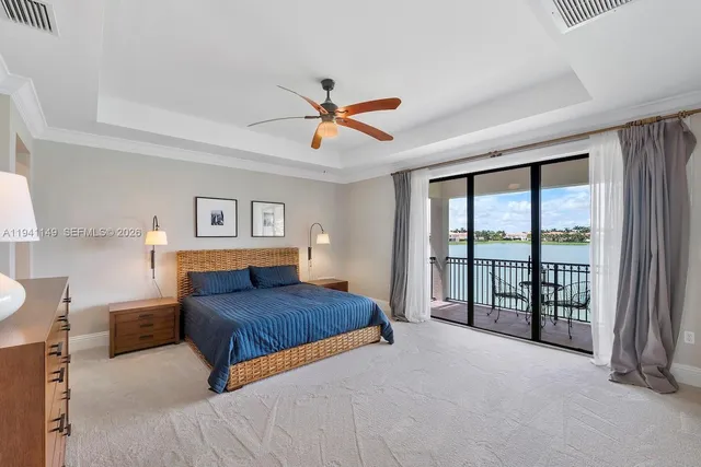 a bedroom with a large bed and a flat tv screen on dresser