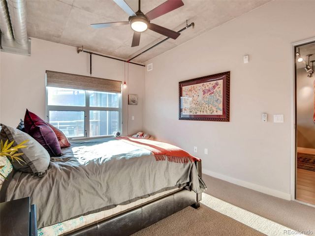 a bedroom with a bed and a painting on the wall