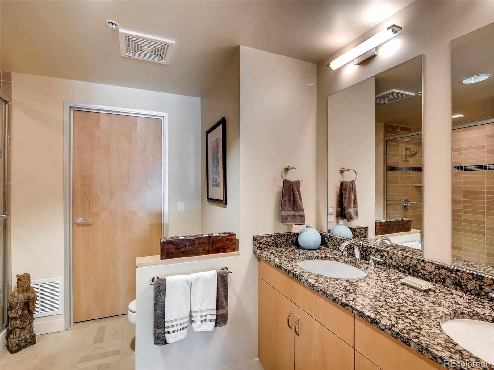 2229 Blake Street, Unit 506 Denver, CO 80205 - Photo 21 of 29 a bathroom with a granite countertop sink and a mirror