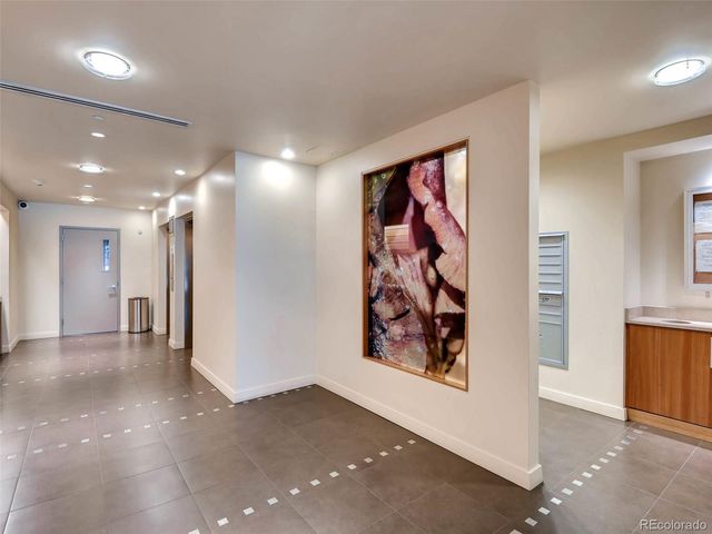 a view of a hallway with bathroom and wooden floor