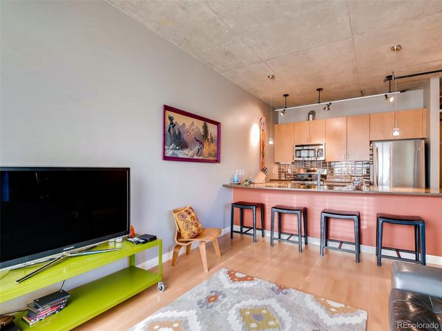 a kitchen with kitchen island a table chairs refrigerator and microwave