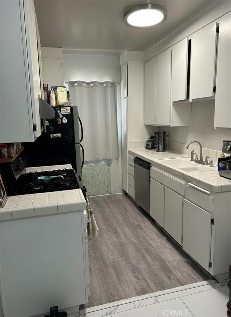 31732 Ridge Rte Road, Unit 211 Castaic, CA 91384 - Photo 7 of 9 a kitchen with sink refrigerator and cabinets