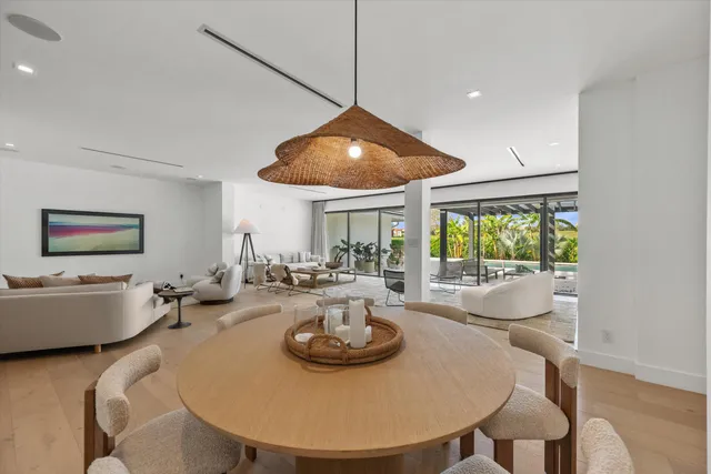 a kitchen with stainless steel appliances granite countertop a sink a stove and a dining table with wooden floor