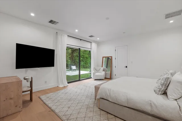 an aerial view of a house with outdoor space and trees all around