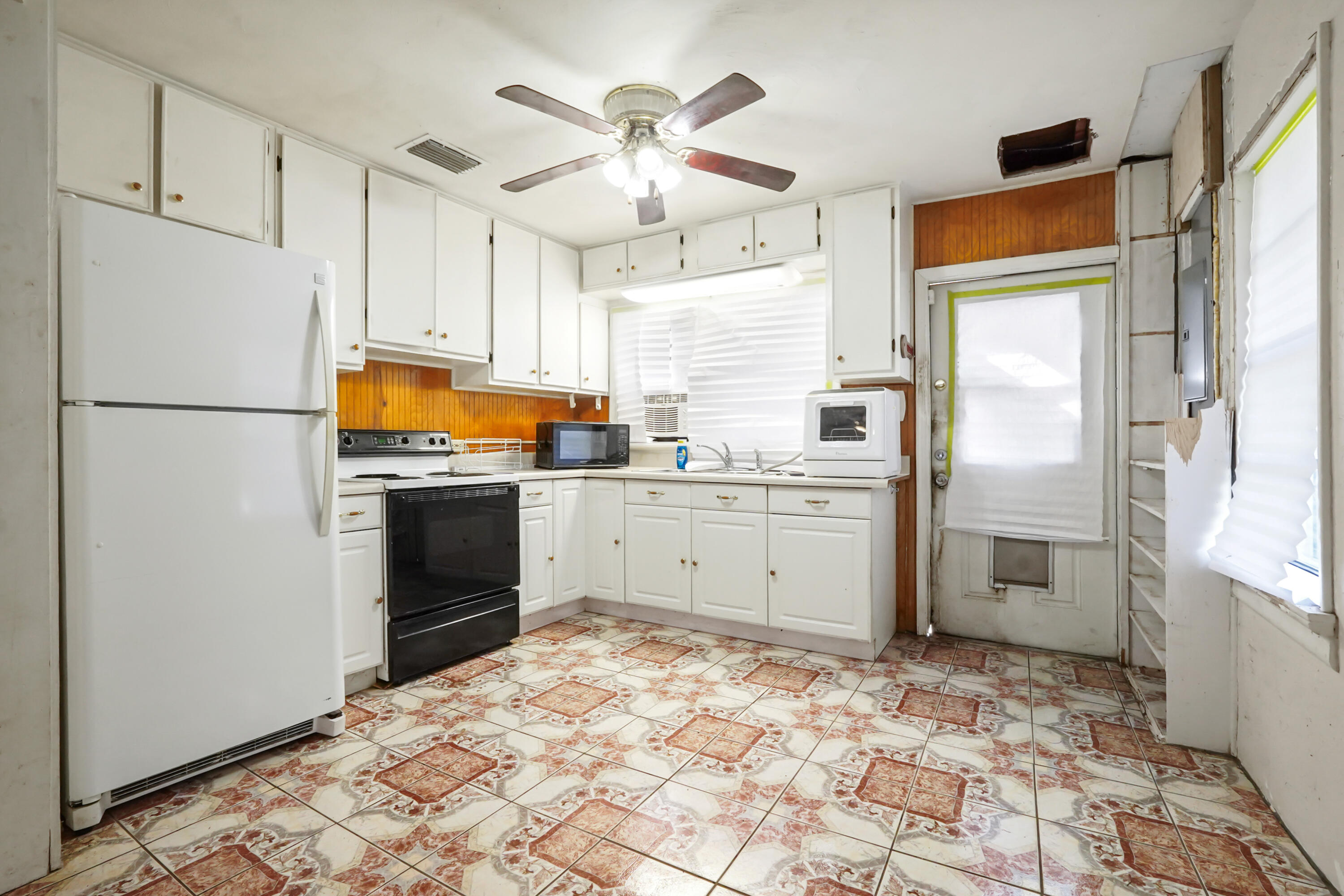 3858 Lakewood Road Palm Springs, FL 33461 - Photo 9 of 39 a kitchen with stainless steel appliances a refrigerator sink and cabinets