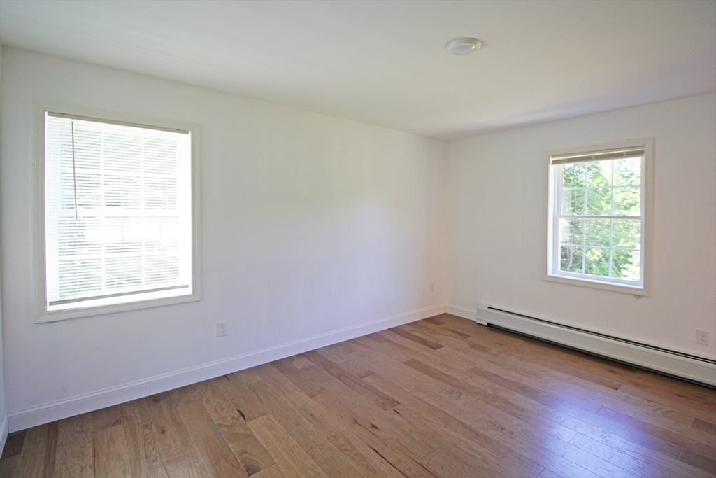 12 Pine Road Williamsburg, MA 01096 - Photo 10 of 24 an empty room with wooden floor and windows