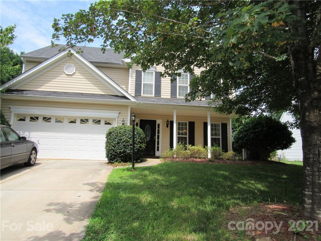 a front view of a house with a yard and trees