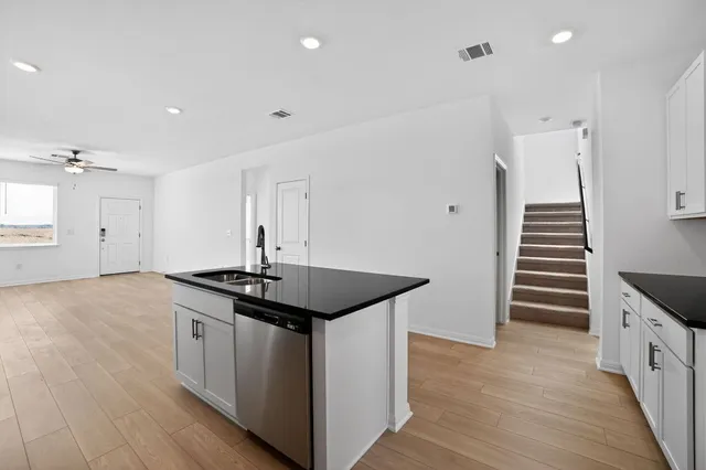 a kitchen with granite countertop a sink and cabinets