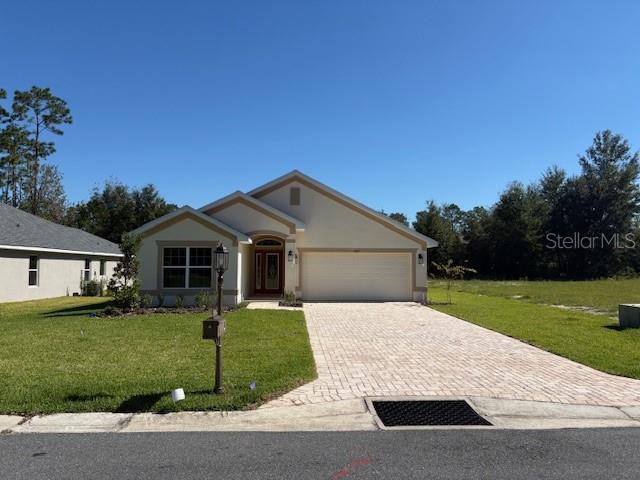 7625 Southwest 180th Circle Dunnellon, FL 34432 - Photo 2 of 21 a front view of a house with a yard and garage