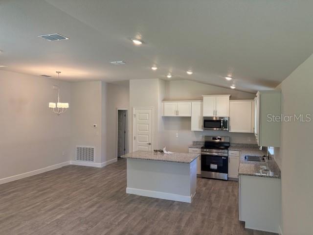 7625 Southwest 180th Circle Dunnellon, FL 34432 - Photo 5 of 21 a kitchen with stainless steel appliances kitchen island granite countertop a stove a sink and a refrigerator
