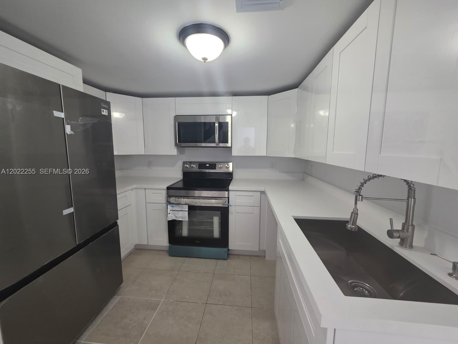 829 Southwest 3rd Street, Unit 831 Miami, FL 33130 - Photo 6 of 21 a kitchen with stainless steel appliances a sink stove and refrigerator