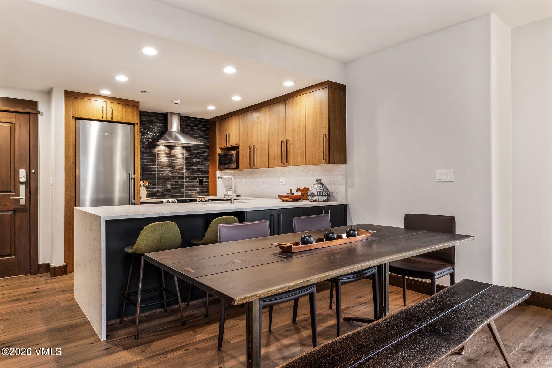 30 Cresta Road, Unit 202 Edwards, CO 81632 - Photo 5 of 23 a kitchen with stainless steel appliances granite countertop a stove a refrigerator a kitchen island and chairs in it