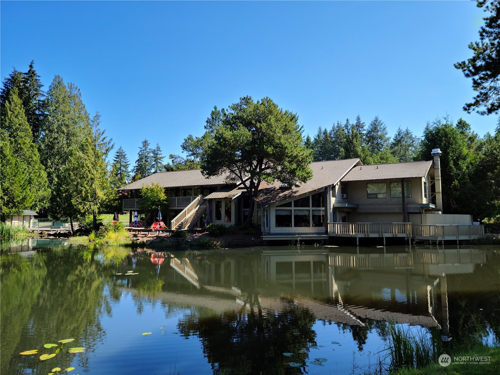 91 East Soderberg Road, Unit C10 Allyn, WA 98524 - Photo 35 of 38 a view of a house with a yard next to a lake