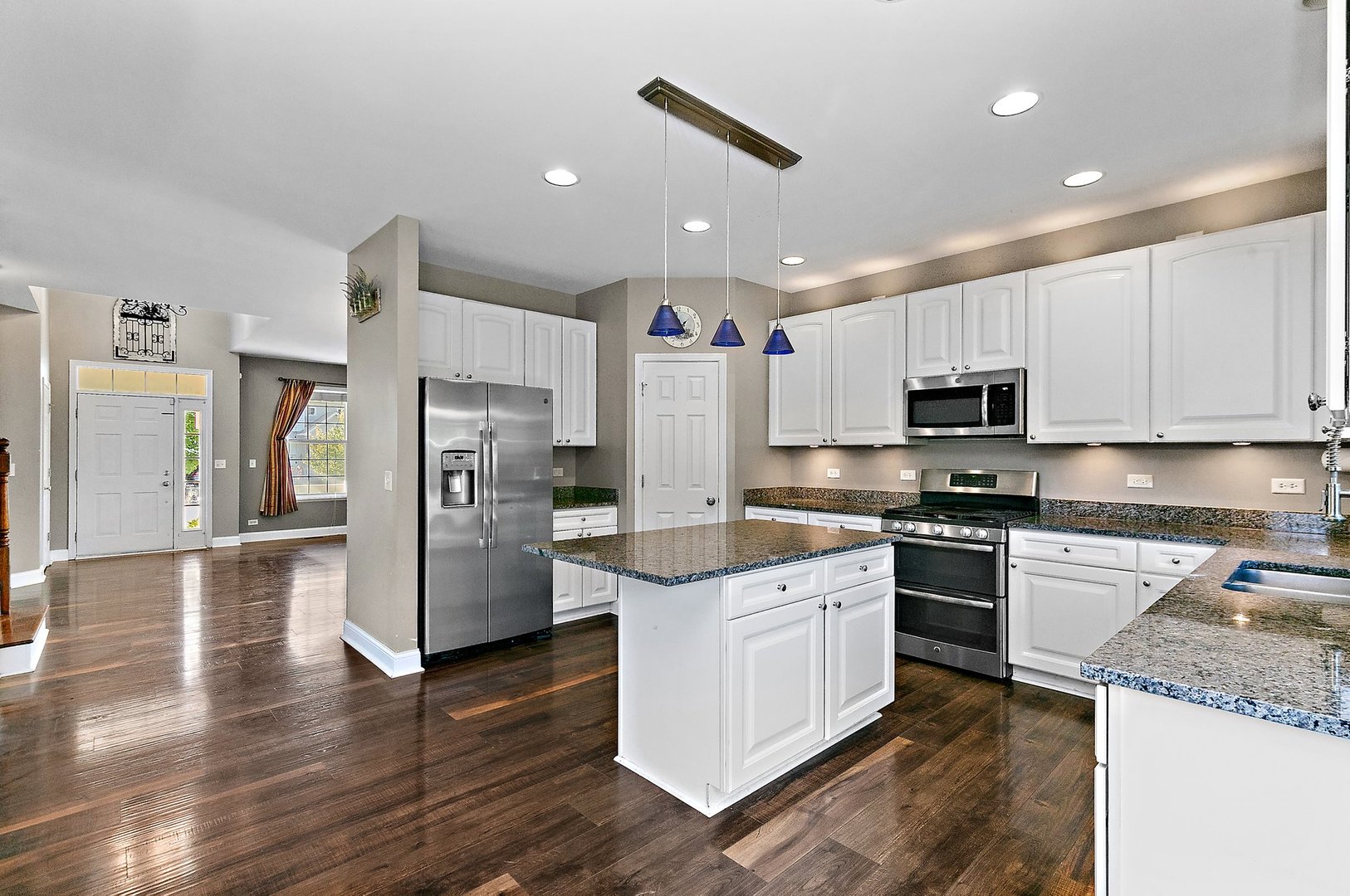 345 Shadow Hill Drive Elgin, IL 60124 - Photo 7 of 35 a kitchen with stainless steel appliances granite countertop a refrigerator a stove top oven a sink and dishwasher with wooden floor