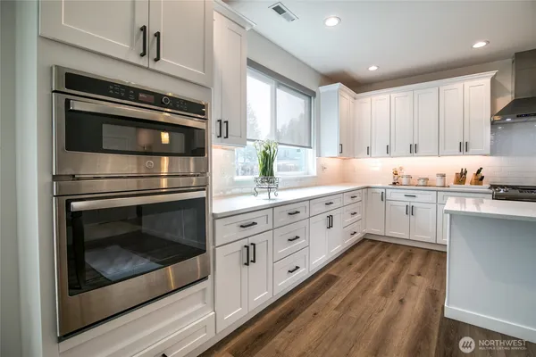 a kitchen with kitchen island granite countertop a sink cabinets and stainless steel appliances