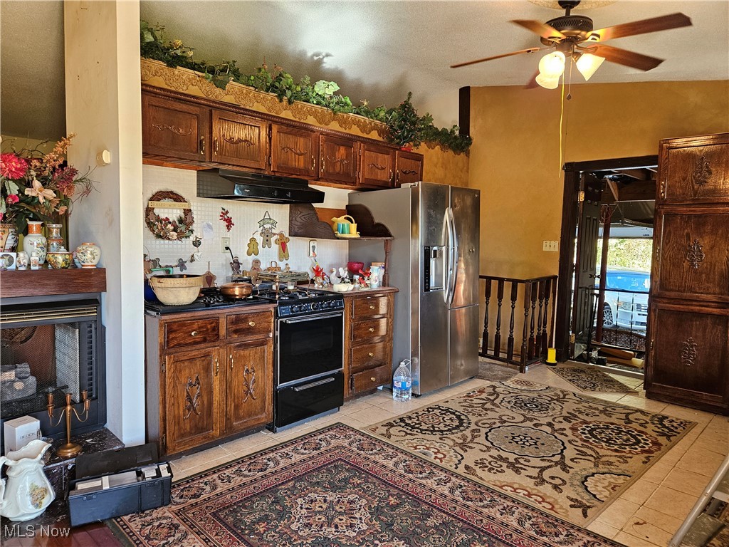 3100 Austinburg Road Ashtabula, OH 44004 - Photo 2 of 12 Kitchen with black stove, vaulted ceiling, stainless steel fridge with ice dispenser, light tile patterned floors, and ceiling fan