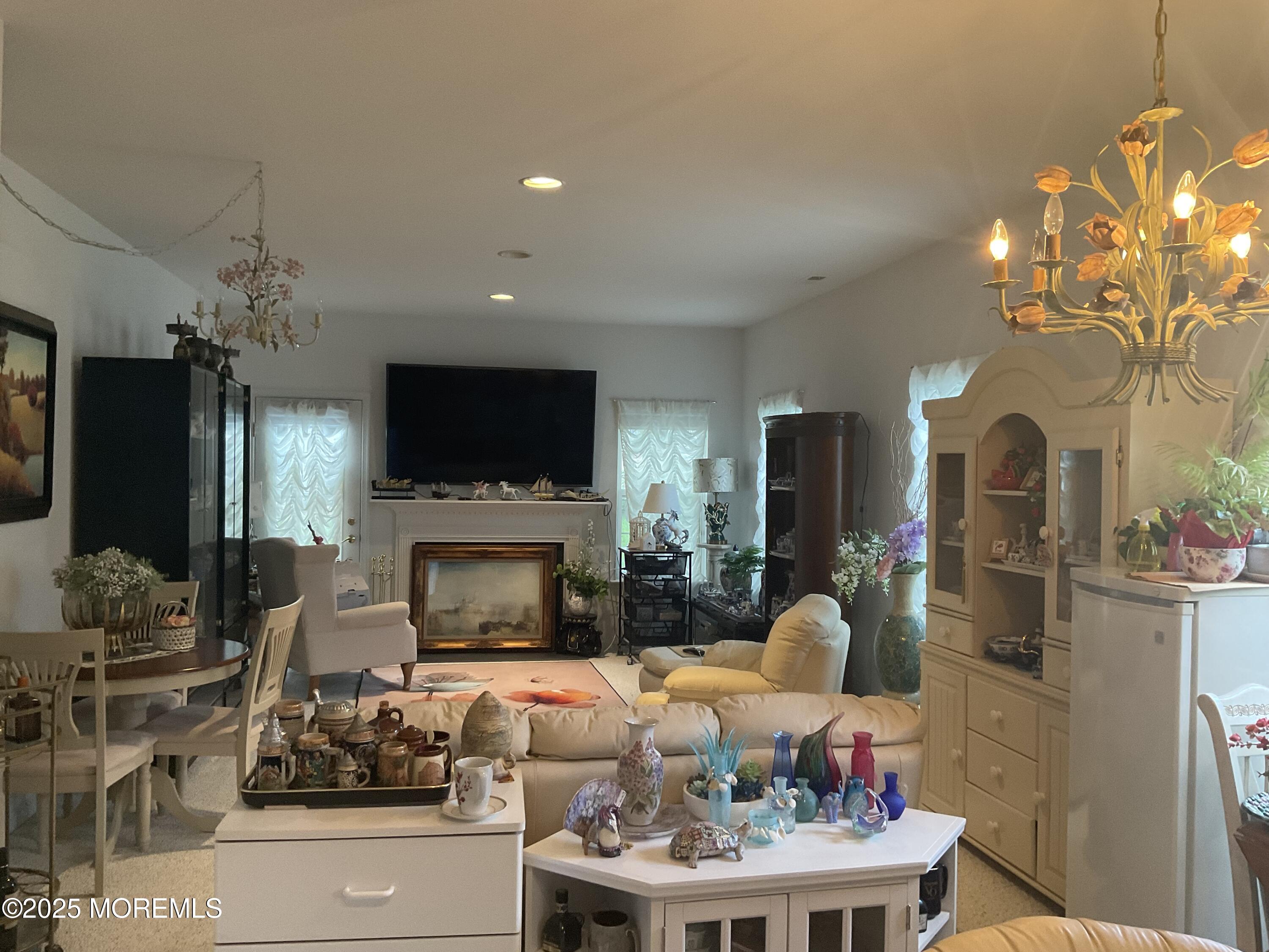 6 Ravenna Road Manchester Township, NJ 08759 - Photo 14 of 14 a living room with furniture a fireplace and a chandelier