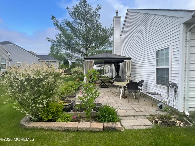a view of a patio with table and chairs and potted plants with wooden fence