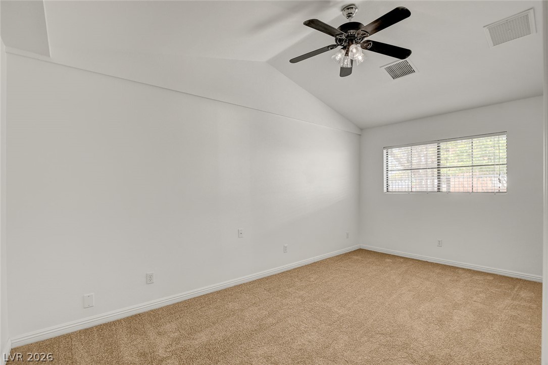 1810 Pinto Road Henderson, NV 89002 - Photo 27 of 53 A well-lit bedroom features vaulted ceilings and soft carpeting, creating a tranquil retreat.