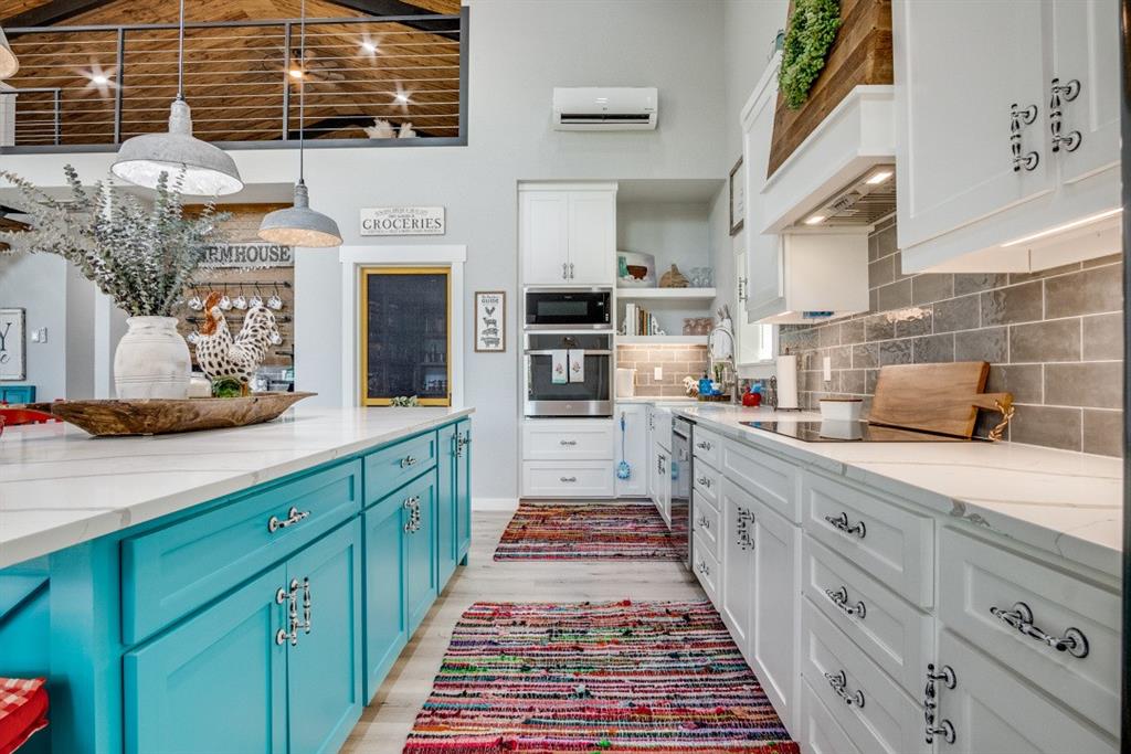 385 Brown Road Palo Pinto, TX 76484 - Photo 5 of 18 a kitchen with stainless steel appliances kitchen island granite countertop a stove and cabinets