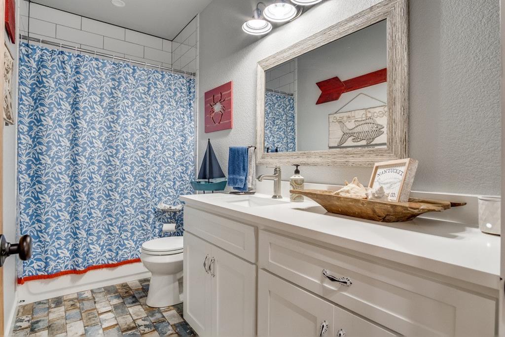 385 Brown Road Palo Pinto, TX 76484 - Photo 9 of 18 a bathroom with a granite countertop toilet sink and mirror