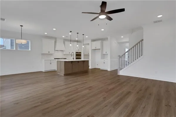 a kitchen with a sink cabinets and wooden floor