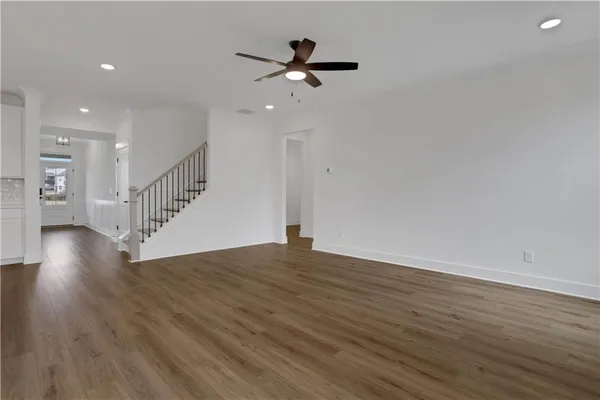 a kitchen with stainless steel appliances granite countertop a sink a stove and a wooden floor