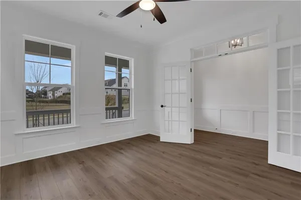 a view of an empty room with wooden floor fireplace and a window