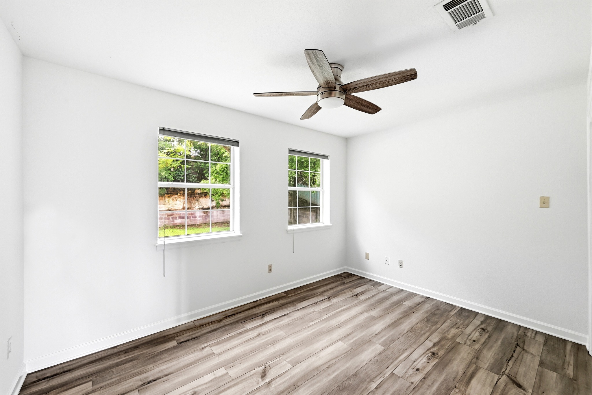 2405 Bahama Road Austin, TX 78733 - Photo 31 of 39 an empty room with wooden floor fan and windows