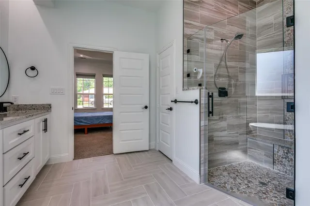 a bathroom with a granite countertop sink a toilet and shower