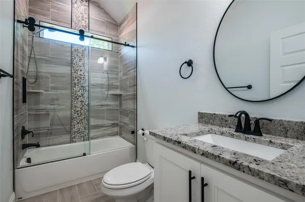 a bathroom with a granite countertop sink toilet and shower
