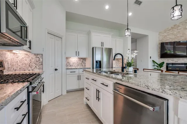 a kitchen with stainless steel appliances granite countertop a sink stove and refrigerator