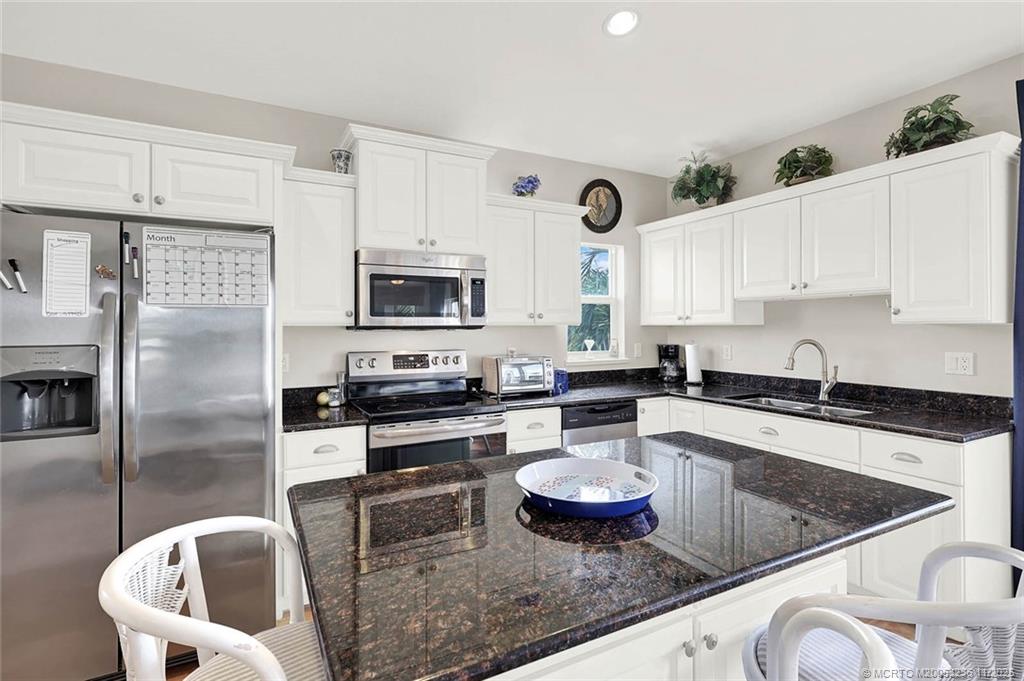 10701 South Ocean Drive, Unit 855 Jensen Beach, FL 34957 - Photo 17 of 67 a kitchen with stainless steel appliances granite countertop a sink stove refrigerator and cabinets
