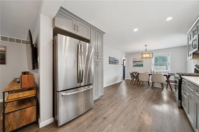 a kitchen with stainless steel appliances a refrigerator and wooden floor
