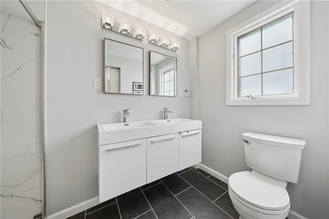 a bathroom with a toilet a sink and mirror