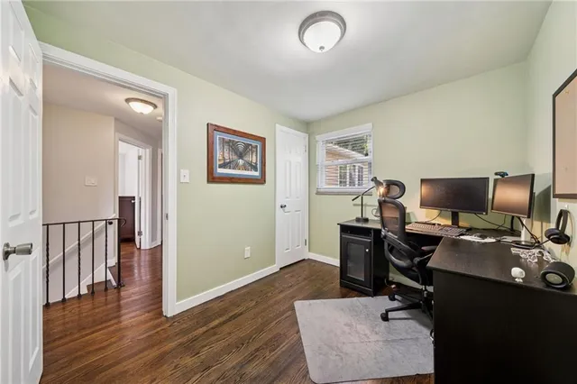 a view of a workspace with furniture and a window