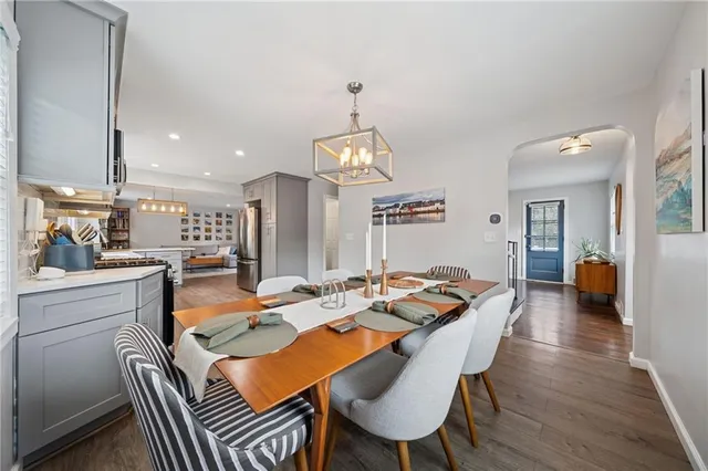 a dining area with furniture a rug and a chandelier