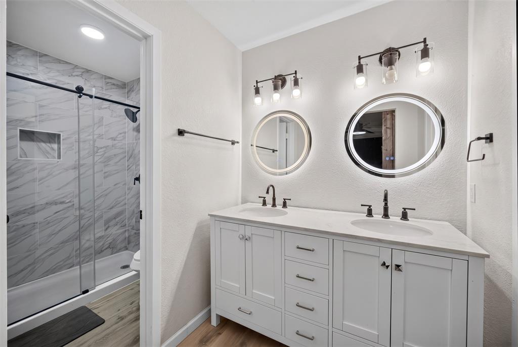 3919 Ridgeoak Way Farmers Branch, TX 75244 - Photo 15 of 28 Dual vanity with white cabinetry, integrated sinks, and individual backlit circular mirrors