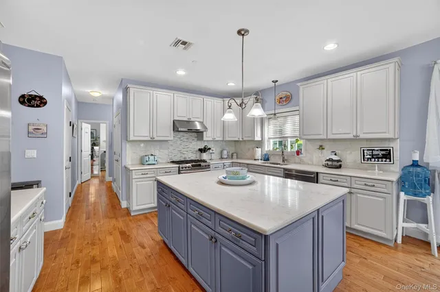 a kitchen with stainless steel appliances granite countertop a sink a stove and a refrigerator