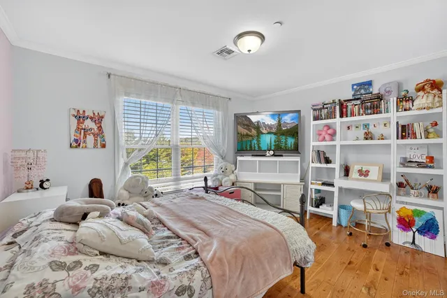 a bedroom with a bed a large window and book shelf