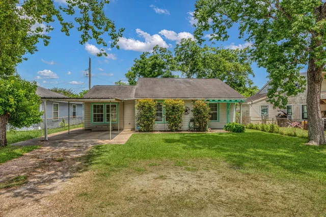 a front view of a house with a yard and trees