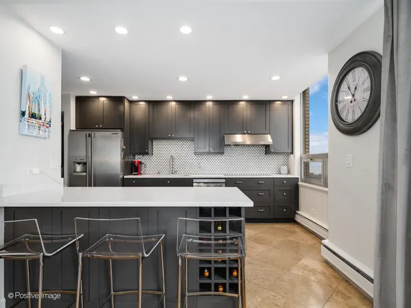 a kitchen with kitchen island granite countertop a sink and a stove