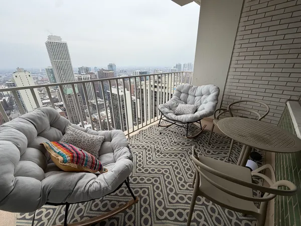 a living room with furniture a flat screen tv and large windows